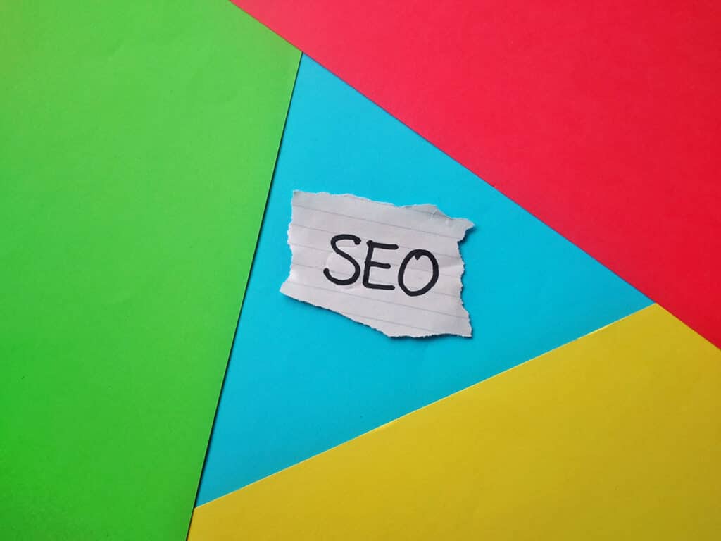 Lapp med texten SEO mot en bakgrund i Googles färger